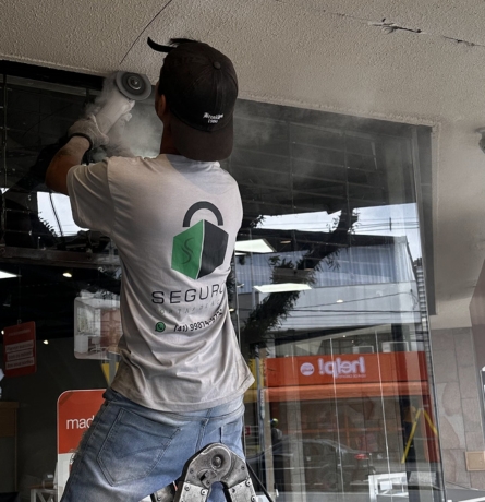 Técnico realizando reparo de emergência em porta de aço em Curitiba